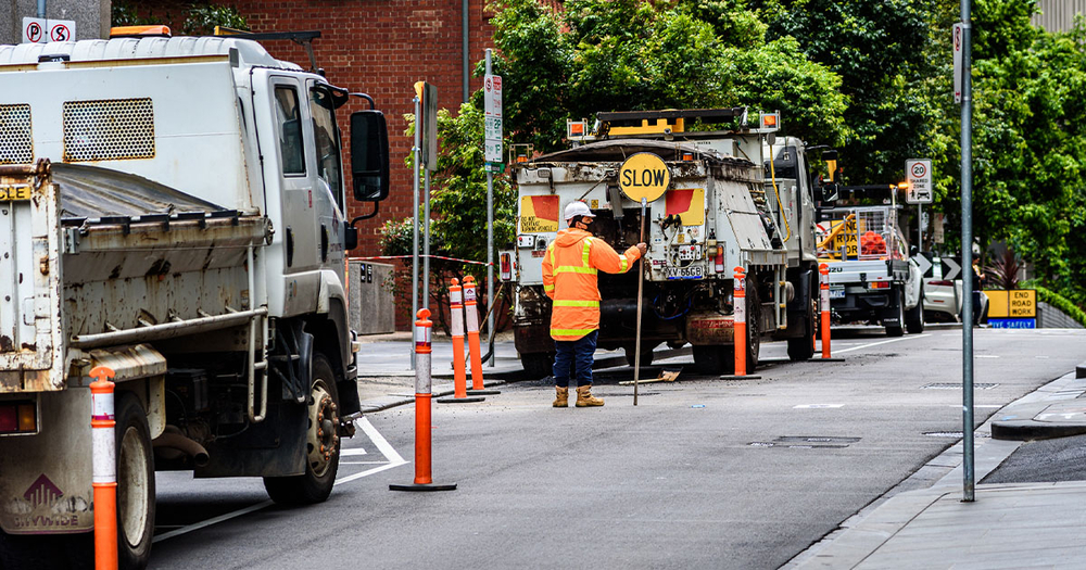 Traffic control worker with slow sign