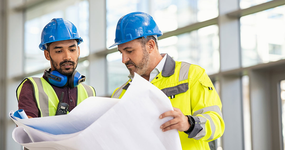 Worker explaining next steps with blueprint