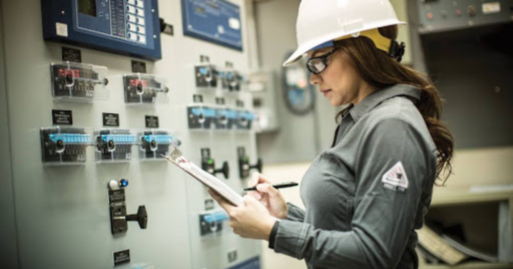 A woman working electrical wearing a white hardhat. A woman working electrical wearing a white hardhat.